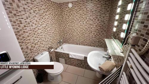 a bathroom with a tub and a toilet and a sink at Little Americas Wyoming Lodge Apartment in Budapest