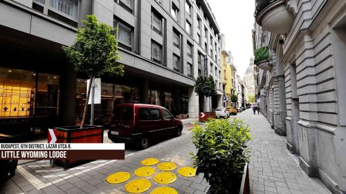 a street with a red van parked on the sidewalk at Little Americas Wyoming Lodge Apartment in Budapest