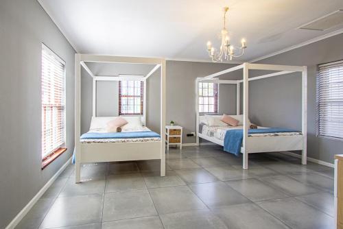 1 dormitorio con 2 camas y lámpara de araña en Berg River Living, en Velddrif