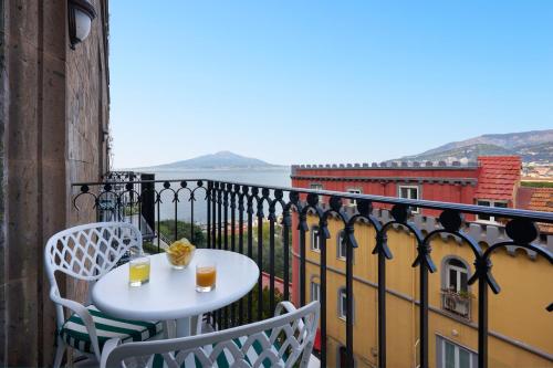 a table and chairs on a balcony with a view of the water at Grand Hotel Capodimonte in Sorrento