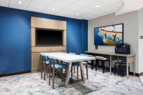 a conference room with a table and chairs and a tv at Hilton Garden Inn Charleston / Mt. Pleasant in Charleston