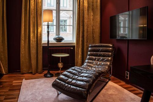 a leather chair in a living room with a window at V Hotel Helsingborg; BW Premier Collection in Helsingborg