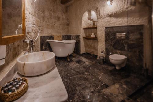 La salle de bains est pourvue d'une baignoire, de toilettes et d'un lavabo. dans l'établissement Aydinli Cave Hotel, à Gorëme