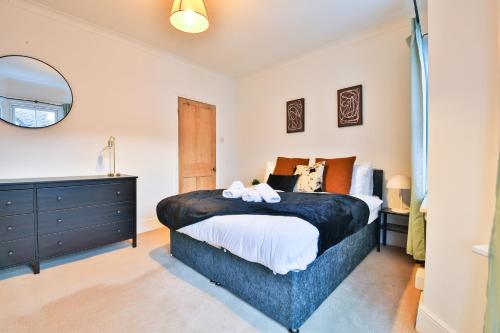 a bedroom with a large bed and a mirror at StayRight 3-Bed Pontcanna House Next to Pontcanna Fields in Cardiff