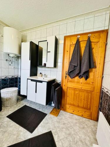 a kitchen with a wooden door and a sink at Apartman Latice in Tomislavgrad
