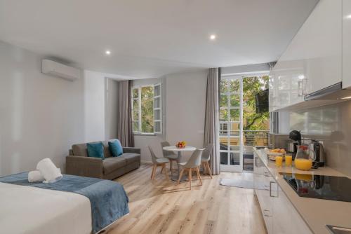 a bedroom with a bed and a kitchen and a living room at Art Deco Central Apartments, Funchal in Funchal