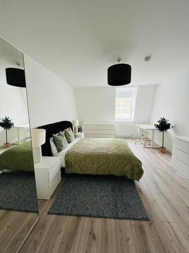 a white bedroom with a bed and a mirror at Stunning New Penthouse Apartment in Southend-on-Sea