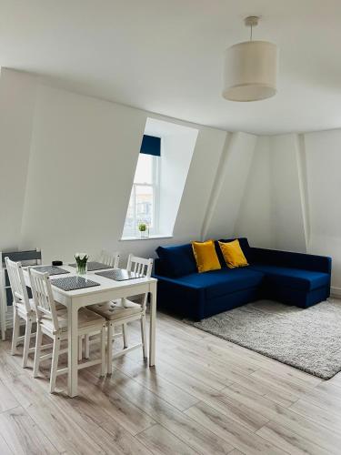 a living room with a blue couch and a table at Stunning New Penthouse Apartment in Southend-on-Sea