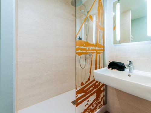 ein Bad mit einem Waschbecken und einem Spiegel in der Unterkunft ibis Styles Ancenis Centre in Ancenis