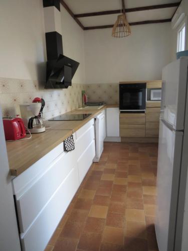  La cuisine est équipée de placards blancs et d'un réfrigérateur. dans l'établissement la toulousaine de Clô, à Toulouse