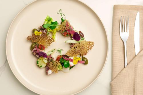 a white plate with food in the shape of a face at Radisson Hotel Ferrara in Ferrara