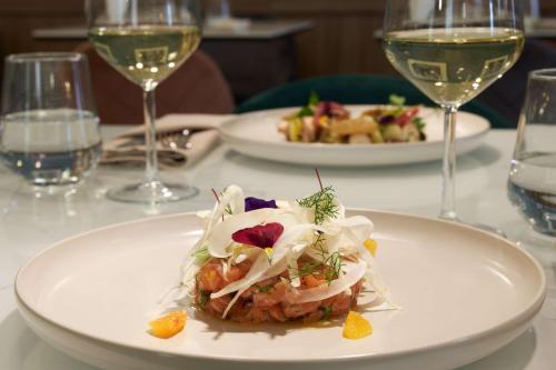 a plate of food on a table with wine glasses at Radisson Hotel Ferrara in Ferrara
