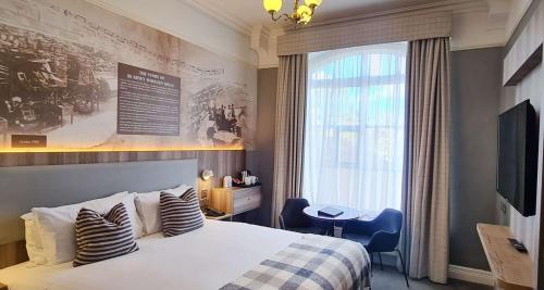 Habitación de hotel con cama y ventana en Blarney Woollen Mills Hotel - BW Signature Collection, en Blarney