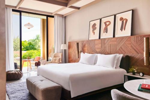 a hotel room with a large bed and a table at Park Hyatt Marrakech in Marrakech