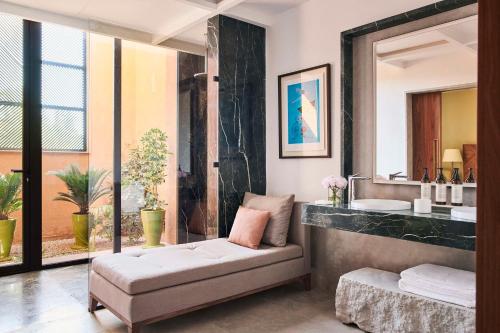 a bathroom with a bench and a sink and a mirror at Park Hyatt Marrakech in Marrakech