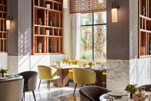 a restaurant with tables and chairs and a window at Park Hyatt Marrakech in Marrakech
