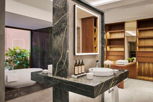 a bathroom with a sink and a bath tub at Park Hyatt Marrakech in Marrakech