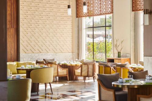 a restaurant with tables and chairs and a window at Park Hyatt Marrakech in Marrakech
