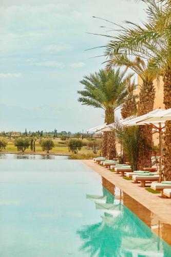 a pool at a resort with chairs and umbrellas at Park Hyatt Marrakech in Marrakech