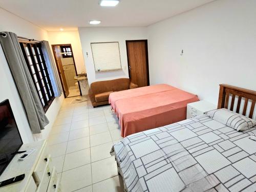 une chambre d'hôtel avec deux lits et un canapé dans l'établissement Flor de Lótus Suites, à Tamandaré