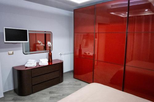 a red cabinet in a bedroom with a mirror at Villa Rea comfort e relax in Carlentini