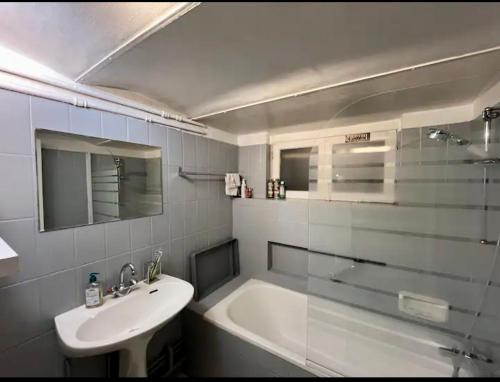 un baño con lavabo y bañera en lumineux havre de paix à 6 minutes de Paris, en Maisons-Alfort
