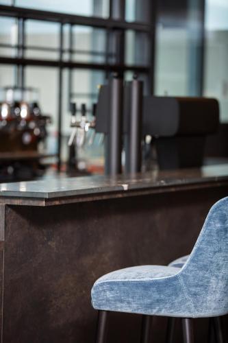 a blue chair sitting in front of a counter at Apollo AchtQuartier Das Hotel am Mondsee in Mondsee