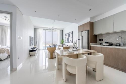 a kitchen and dining room with a table and chairs at 2BR Beachfront Gem with Dazzling Views of the Palm in Dubai