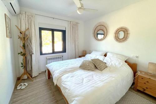 ein Schlafzimmer mit einem großen weißen Bett und zwei Spiegeln in der Unterkunft Casa Ardilla in Altea