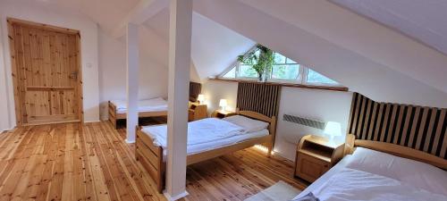a attic bedroom with two beds and a window at Apartamenty Poddąbie1 in Poddąbie