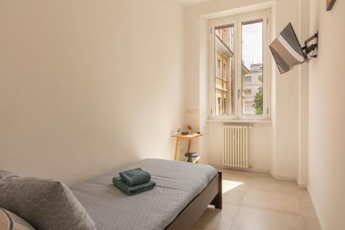 a white room with a bed and a window at Domus Eroi in Rome