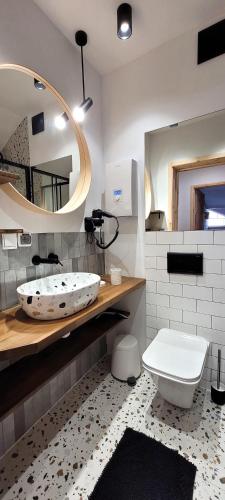 a bathroom with a tub and a toilet and a mirror at Apartamenty Poddąbie1 in Poddąbie