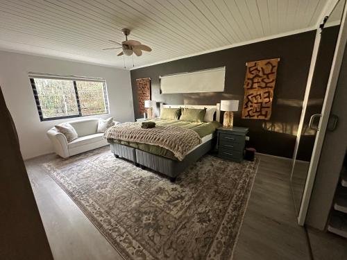 a bedroom with a bed and a couch at Florie se Huis in Paarl