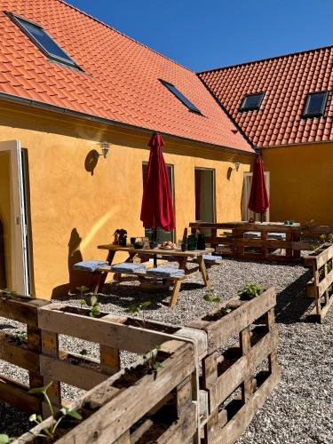 a group of picnic tables with umbrellas in front of a building at Charming holiday apartment - Beate in Ebeltoft