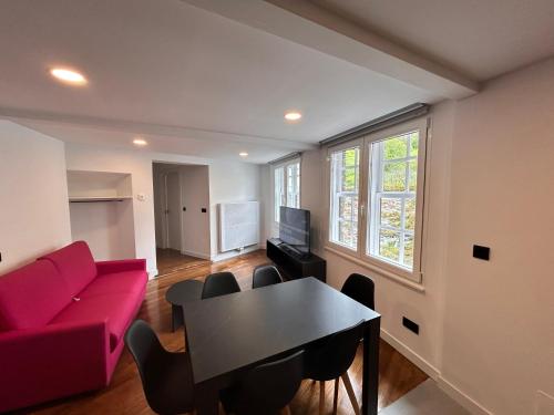 a living room with a red couch and a table at APARTAMENTOS NADA Ó NORTE Centro in Viveiro