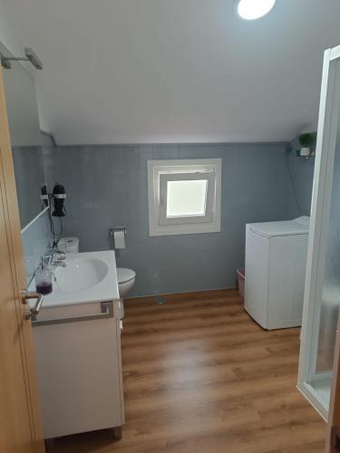a small bathroom with a sink and a window at Casa en San Pantaleón in Paderne