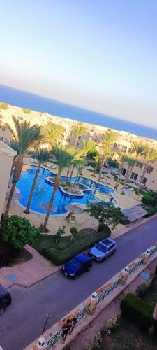 una vista aérea de una playa con palmeras y coches en Sunset Pearle Sahl Hashish, en Hurghada