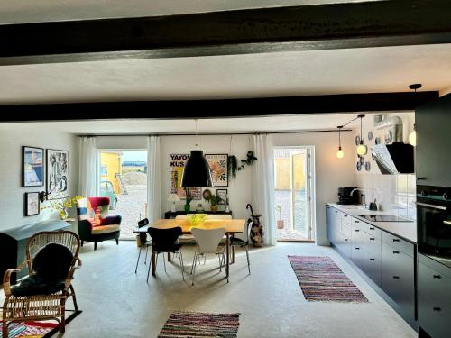 Ellens Have, lejlighed Beate في إيبلتوفت: مطبخ وغرفة معيشة مع طاولة وكراسي