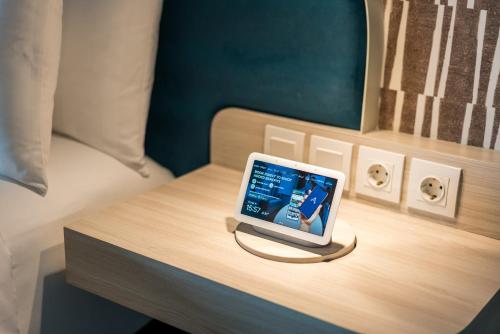 a tablet computer sitting on a table on a bed at Aston Bintaro Hotel & Conference Center in Kampungutan