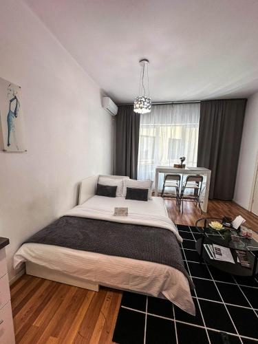 a bedroom with a large bed and a table at Sunrise Apartments City Center in Bucharest