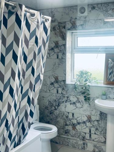 a bathroom with a toilet and a sink and a window at Royal fikiri house in Birmingham