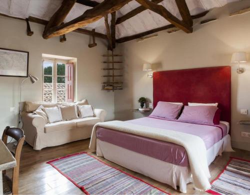 a bedroom with a large bed and a couch at Apartamento Coral in Revilla de Cepeda