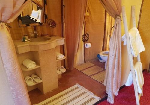 a bathroom with a sink and a toilet in a room at Sahara Luxury Camp & Camel Trek in Merzouga