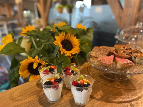 a table topped with desserts and a bowl of fruit at Hotel De Gravin in 's-Gravenzande