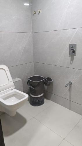 uma casa de banho com um WC e uma lata de lixo em hotel gateway inn em Ahmedabad