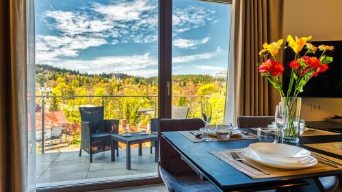 a dining room with a table and a large window at Apartamenty z basenem i saunami STONE HILL RESORT II VIP Centrum by Royal Aparts in Szklarska Poręba