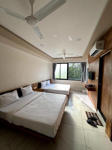 a bedroom with two beds and a large window at hotel gateway inn in Ahmedabad