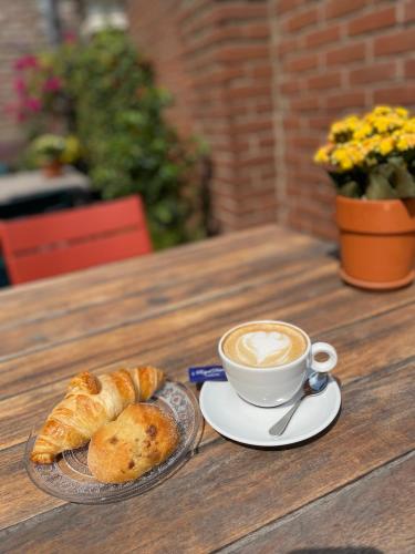 a cup of coffee and croissants on a table at Hotel De Gravin in 's-Gravenzande
