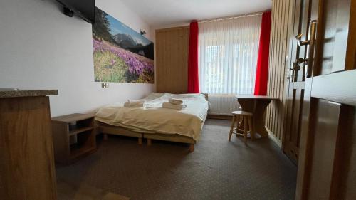 um quarto com uma cama e uma janela com cortinas vermelhas em Willa Baja 2 em Zakopane