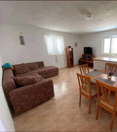 a living room with a couch and a table at Apartments Silba in Silba
